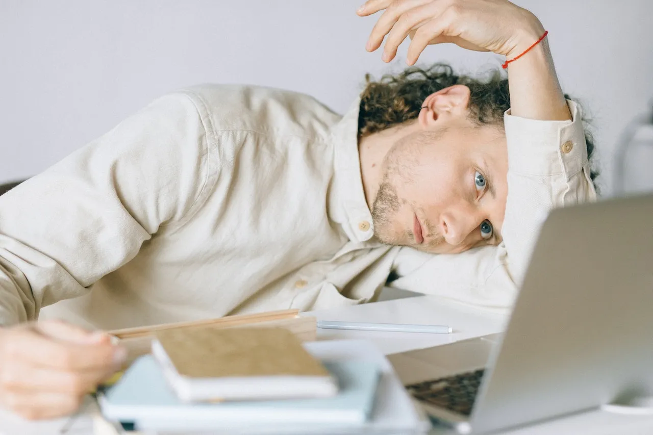 A man slumped over looking at his laptop